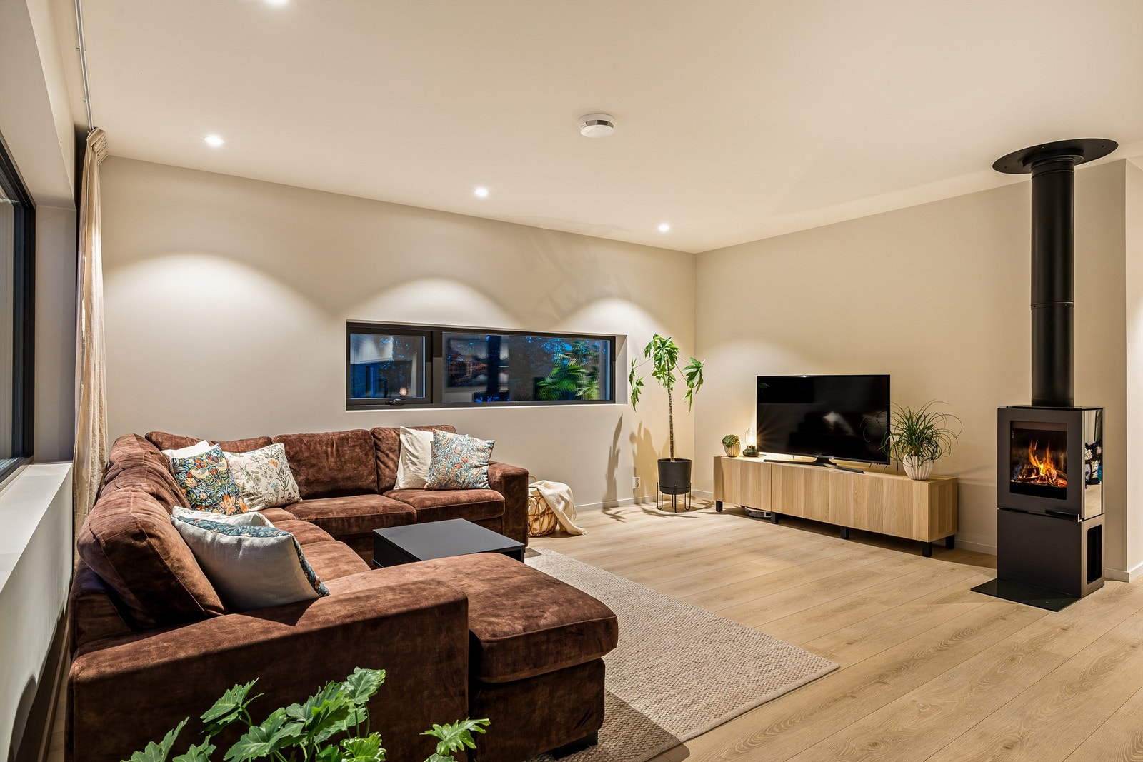 Stuen er oppmalt i en lun og dempet farge der kveldsroen lett kan senke seg foran peisen Galleribilde