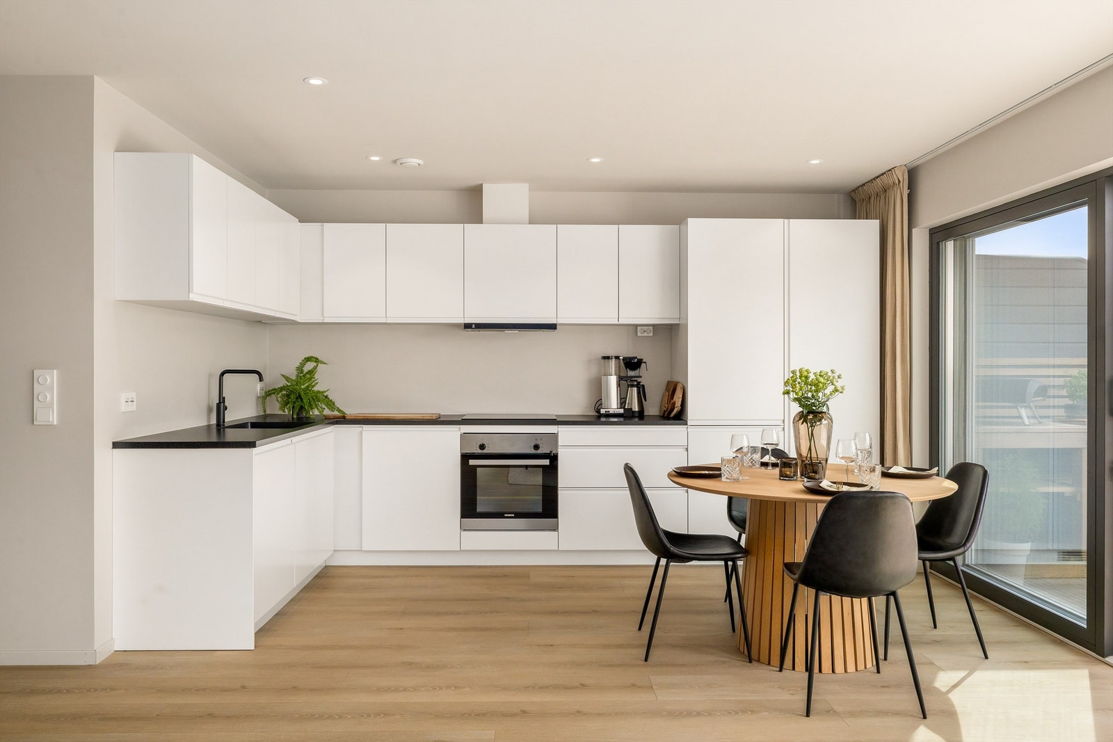 Kjøkkenet har slette fronter i en lys utførelse Galleribilde