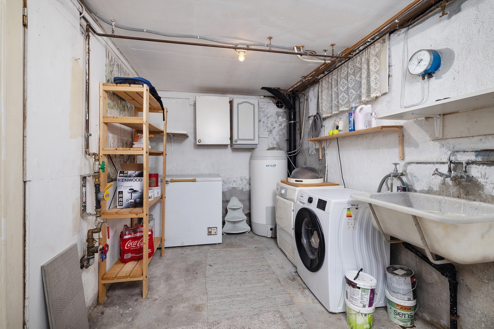 Vaskekjelleren har vegghengt utslagsvask og opplegg for vaskemaskin. Galleribilde