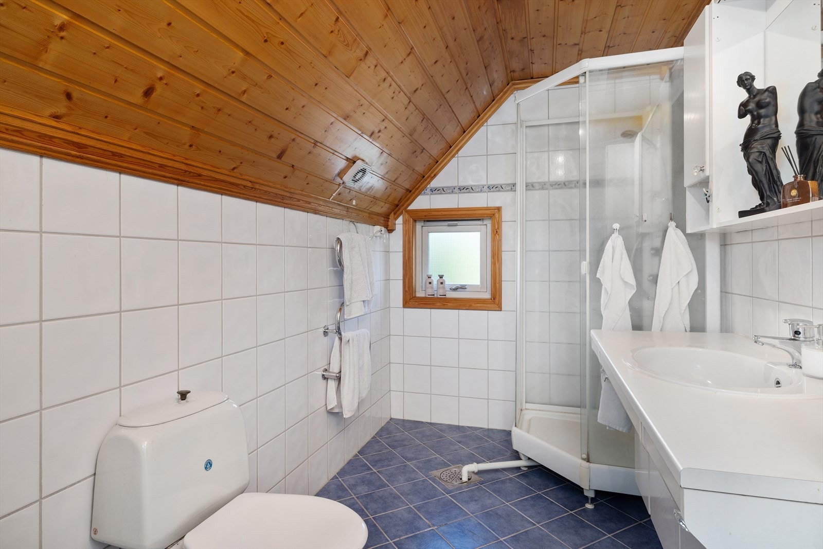 Badet er flislagt med elektriske varmekabler, og er utstyrt med innredning med servant, toalett og dusjkabinett. Galleribilde