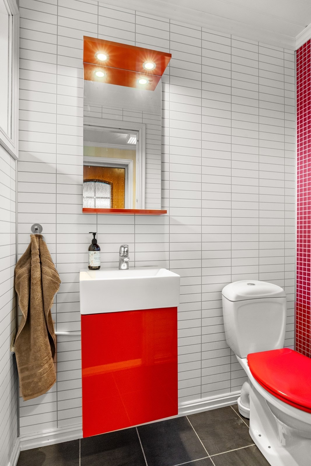 Praktisk gjestetoalett som inneholder gulvstående toalett, innredning m/servant og speil. Galleribilde