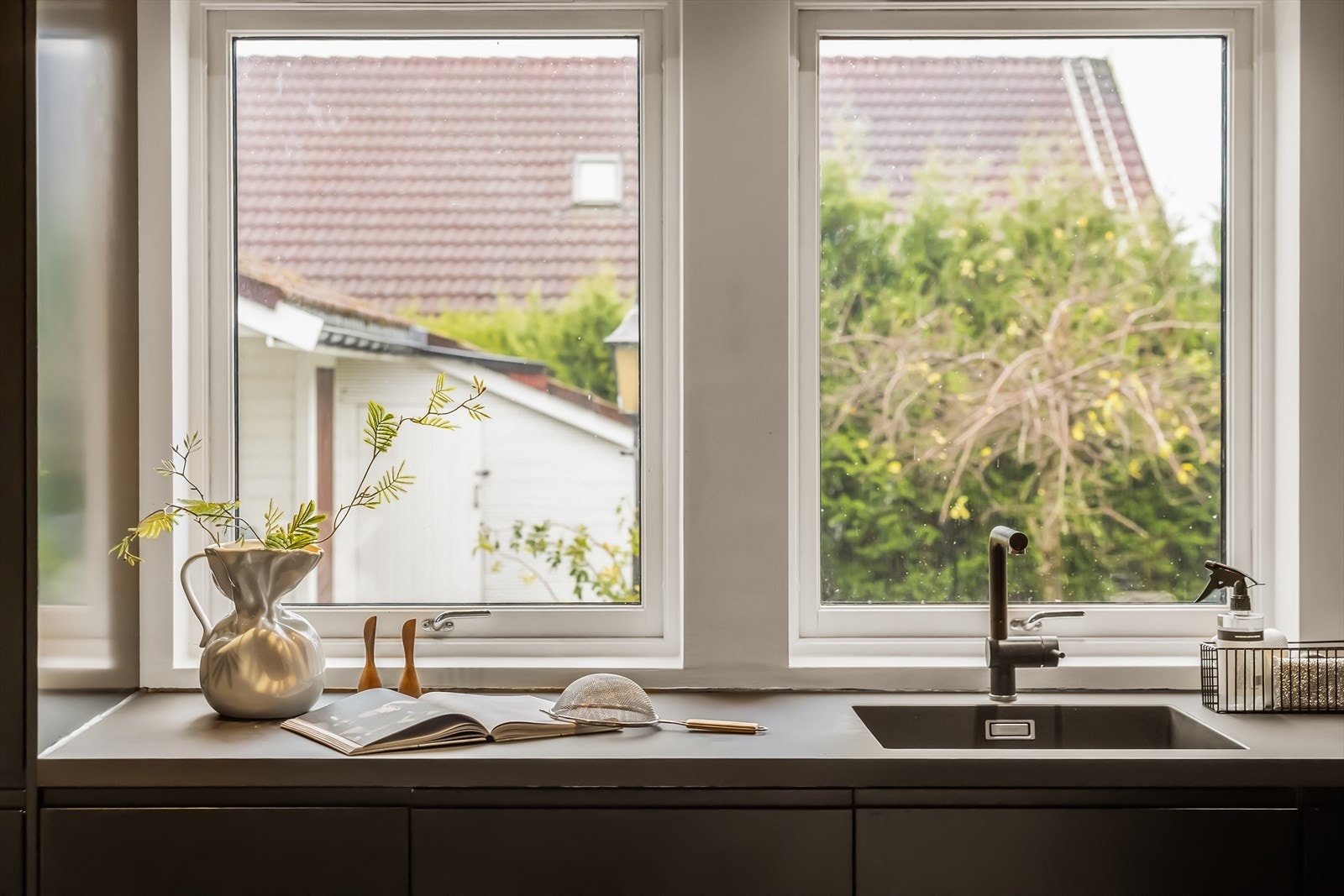 - Stilfult med sorte glatte fronter, benkeplate av laminat og uttrekkbar blandebatteri - Galleribilde