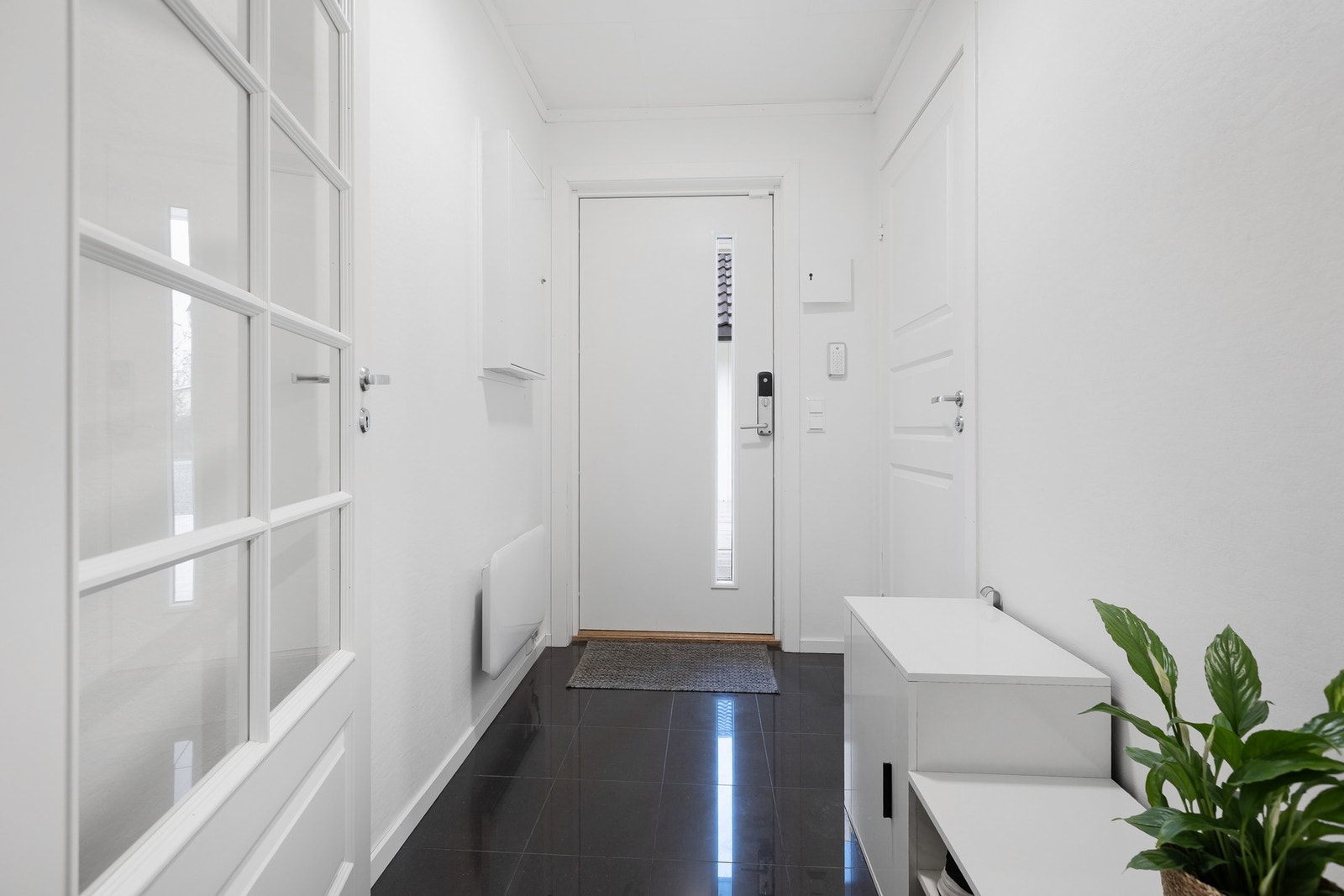 Innbydende gang med flislagt gulv, lyse vegger og god plass til oppbevaring. Galleribilde