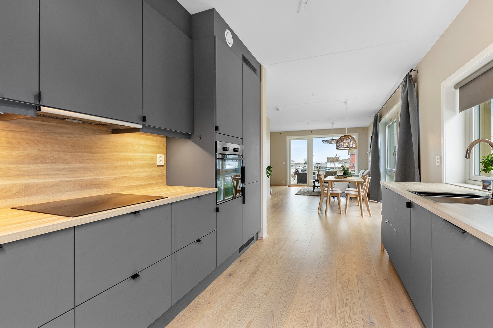 Nydelig kjøkkeninnredning med slett front i en meget spennende gråfarge, med lys laminert benkeplate. Godt med skap- og benkeplass. Galleribilde