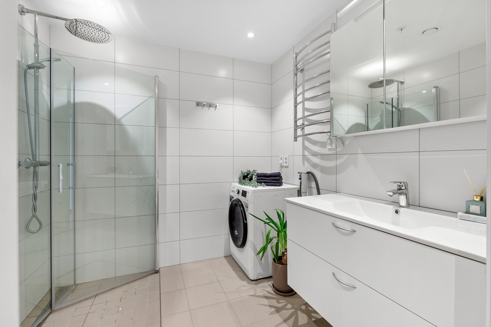 Innredning med servantskap med speil/lys, vegghengt toalett og dusjhjørne med glassdører. Opplegg for vaskemaskin og tørketrommel Galleribilde