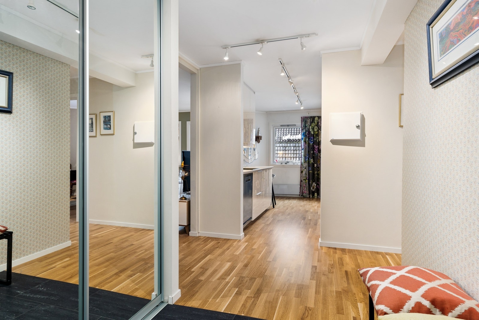 Romslig entre som fører inn til leilighetens soverom og bad Galleribilde