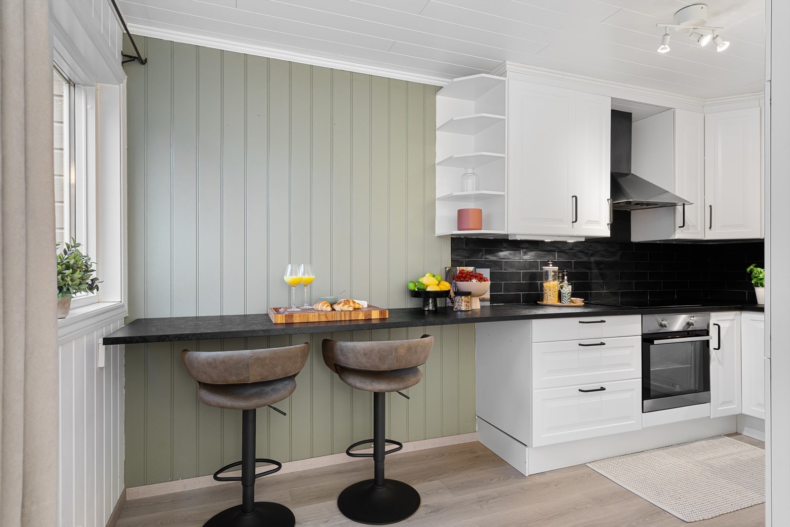 Kjøkken med spiseplass ved kjøkkenvindu. Galleribilde