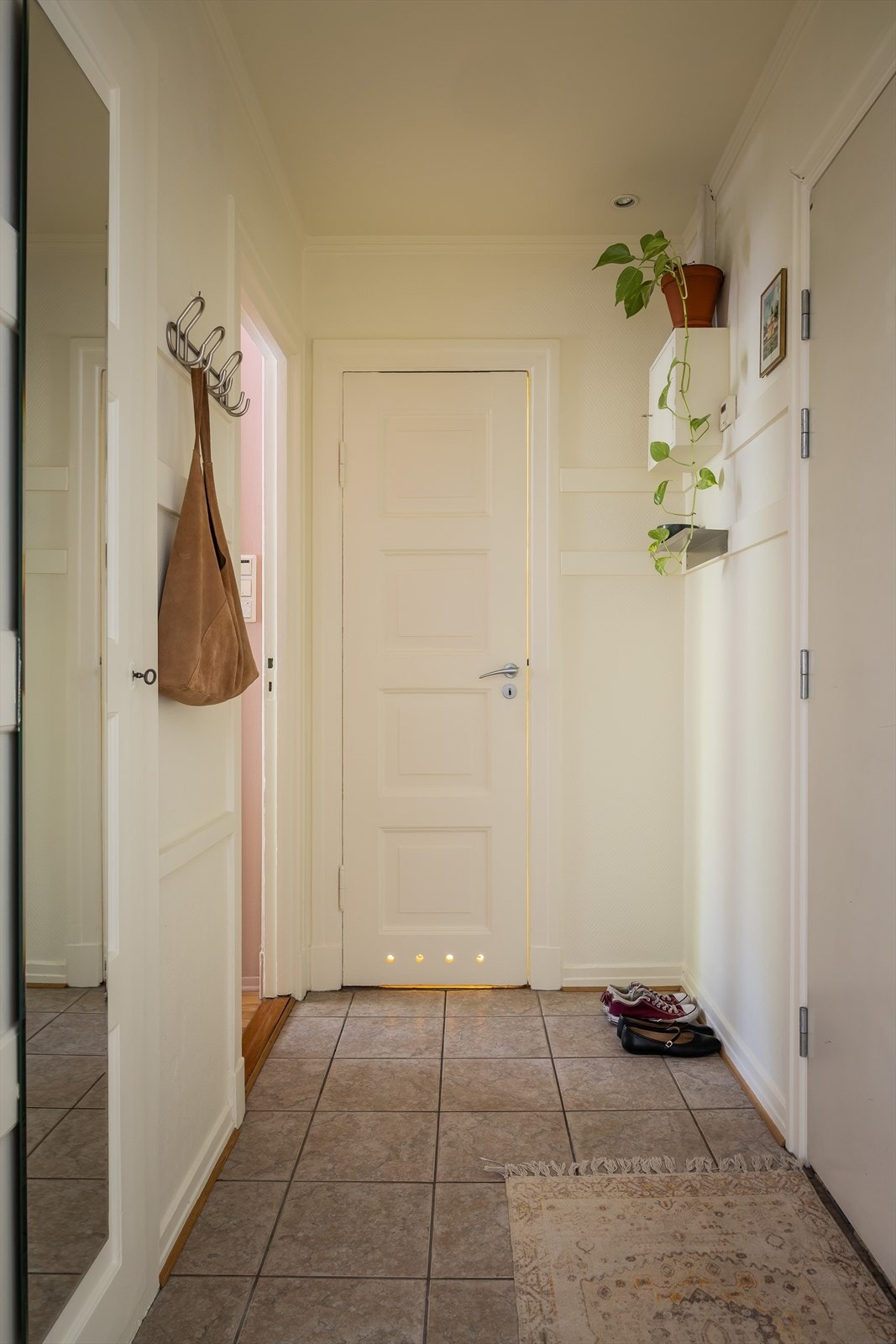 I entréen finner man den innvendige boden som rommer alt man trenger tilgang på i hverdagen: Støvsuger, tørkestativ, strykebrett, jakker og sko. Fra entréen kommer man videre til bad, toalett og soverom. Galleribilde