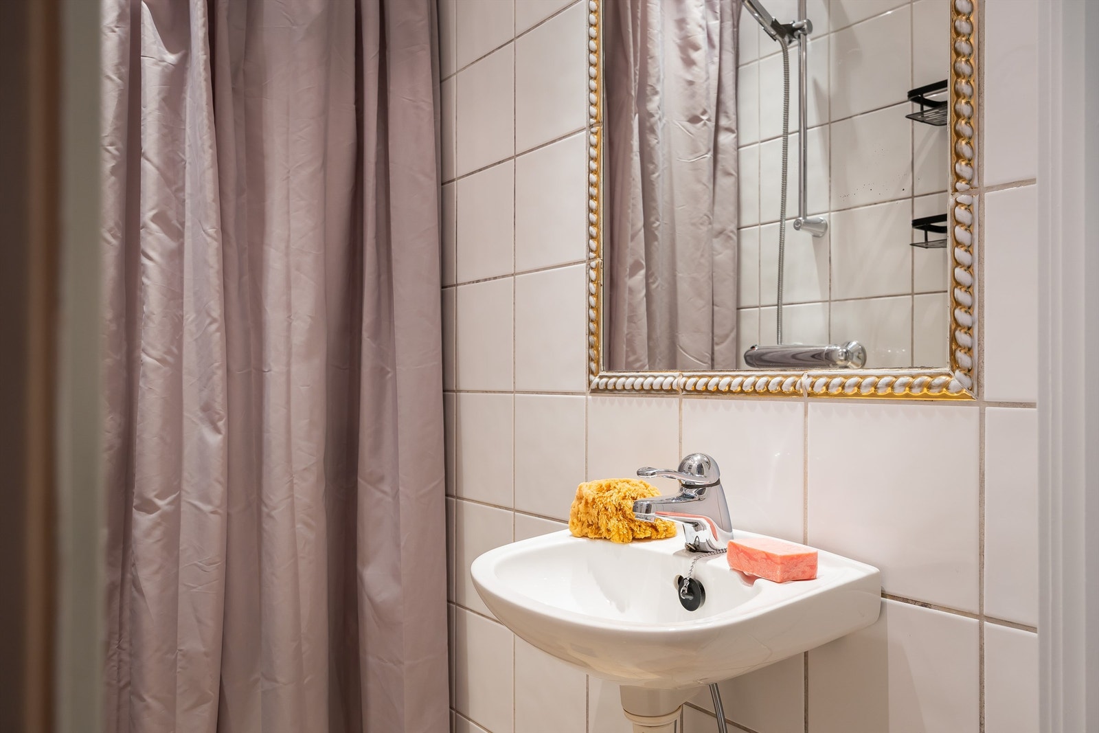 På badet er det et klassisk innrammet speil med gulldetaljer. Galleribilde