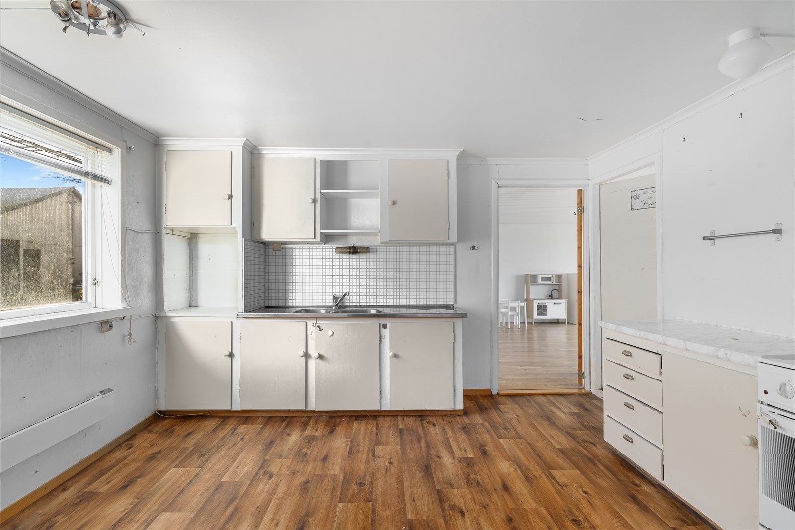 Kjøkkeninnredning med slett fronter og benkeplate/vask av stål. Galleribilde