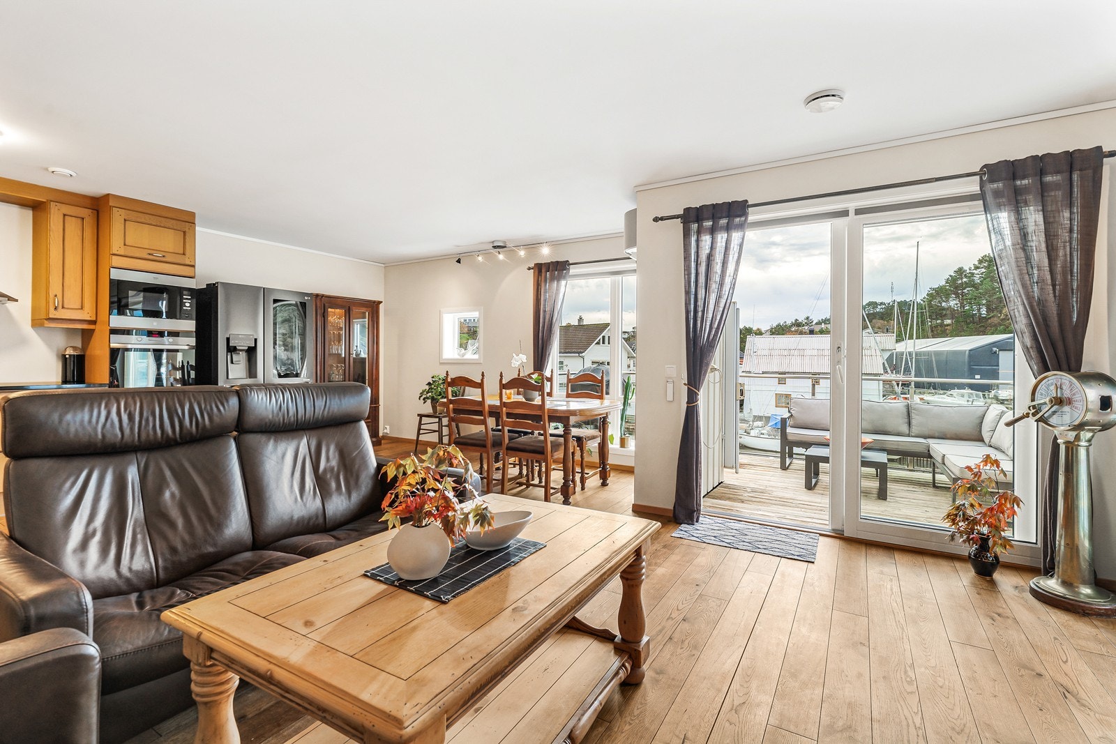 Den lyse og luftige stuen har god plass til både sofagruppe og spisebord, med gjennomgående heltregulv og malte veggflater Galleribilde