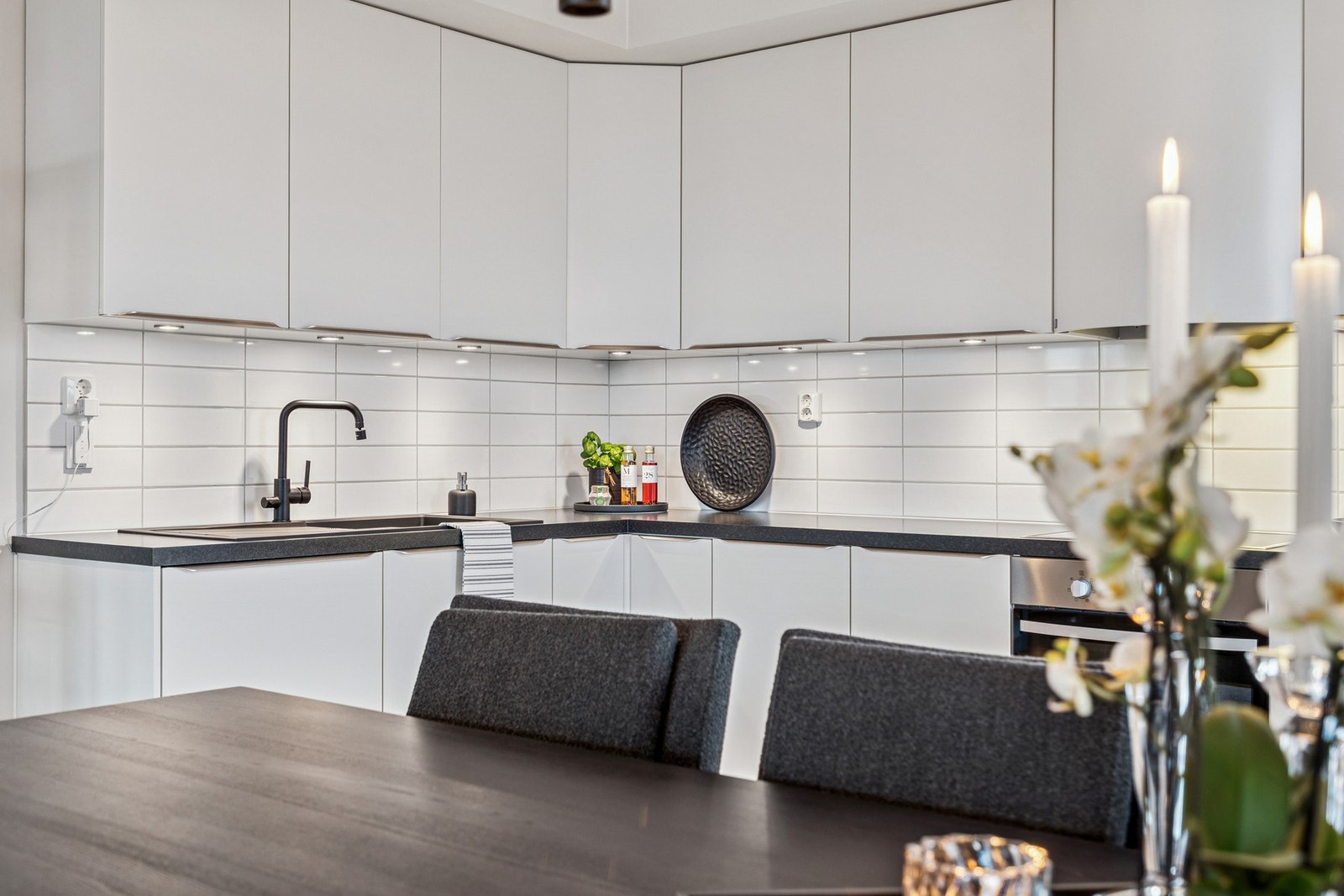 Innredningen er moderne med glatte fronter, laminert benkeplate, benkebelysning og fliser mellom benk og overskap. Galleribilde