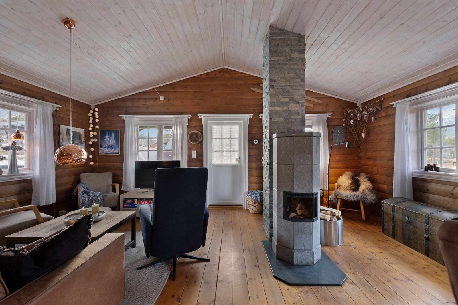 Vedovn i naturstein bidrar med jevn varme i stuen, og gir en lun atmosfære. Galleribilde