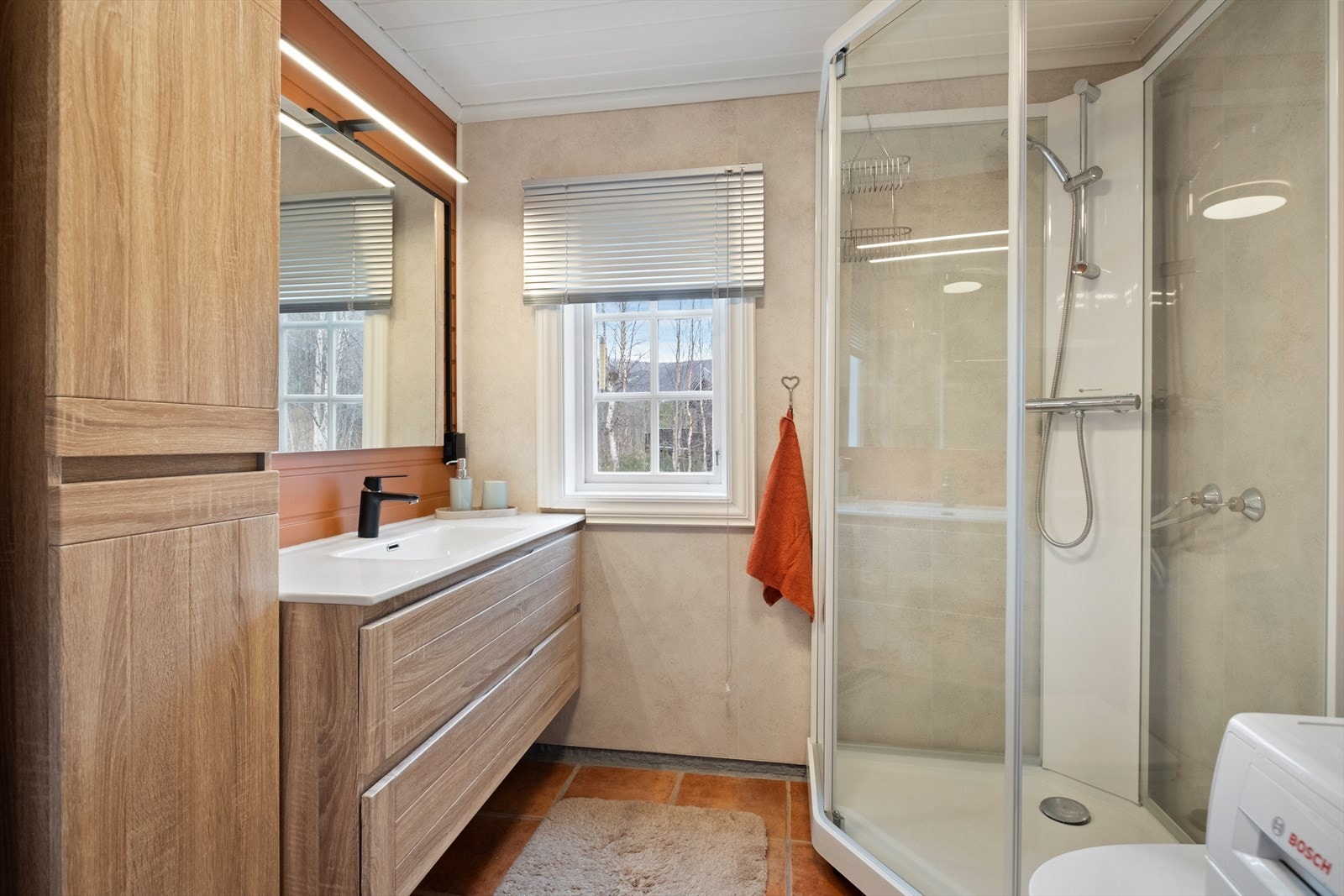 Bad med fliser og varme på gulv og baderomsplater på tre av veggene. Galleribilde