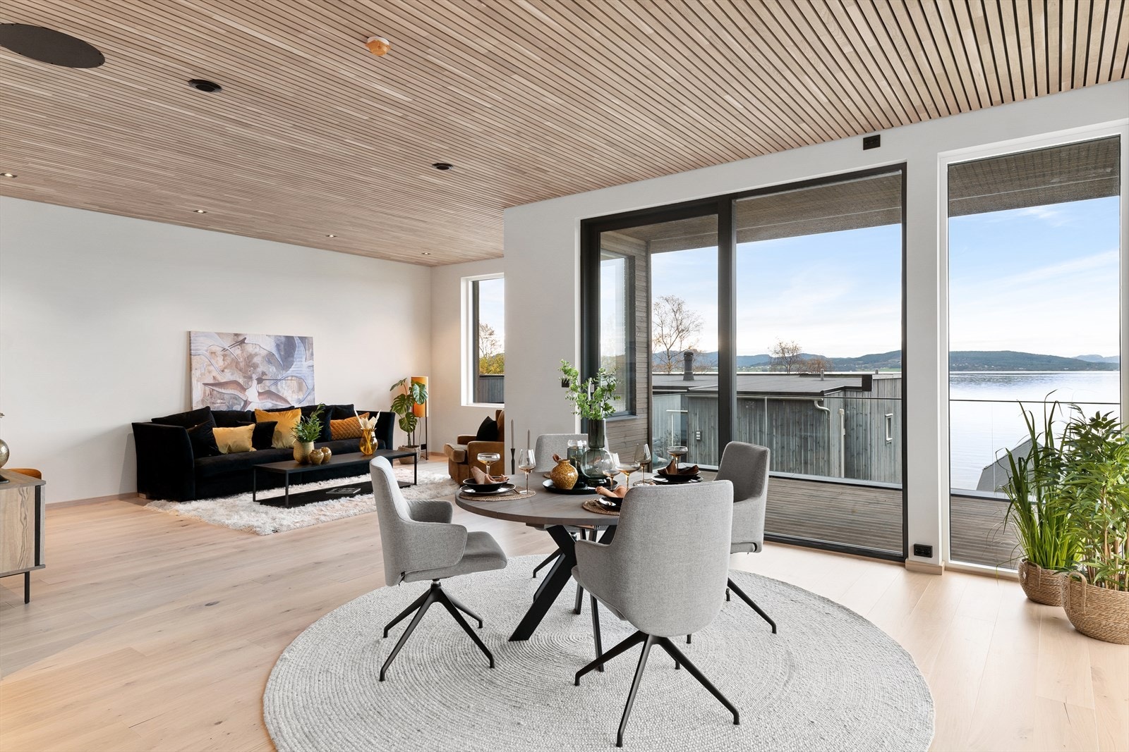 Lys og luftig stue med eikespiler i himling - Eikedetaljer går igjen gjennom hele boligen Galleribilde