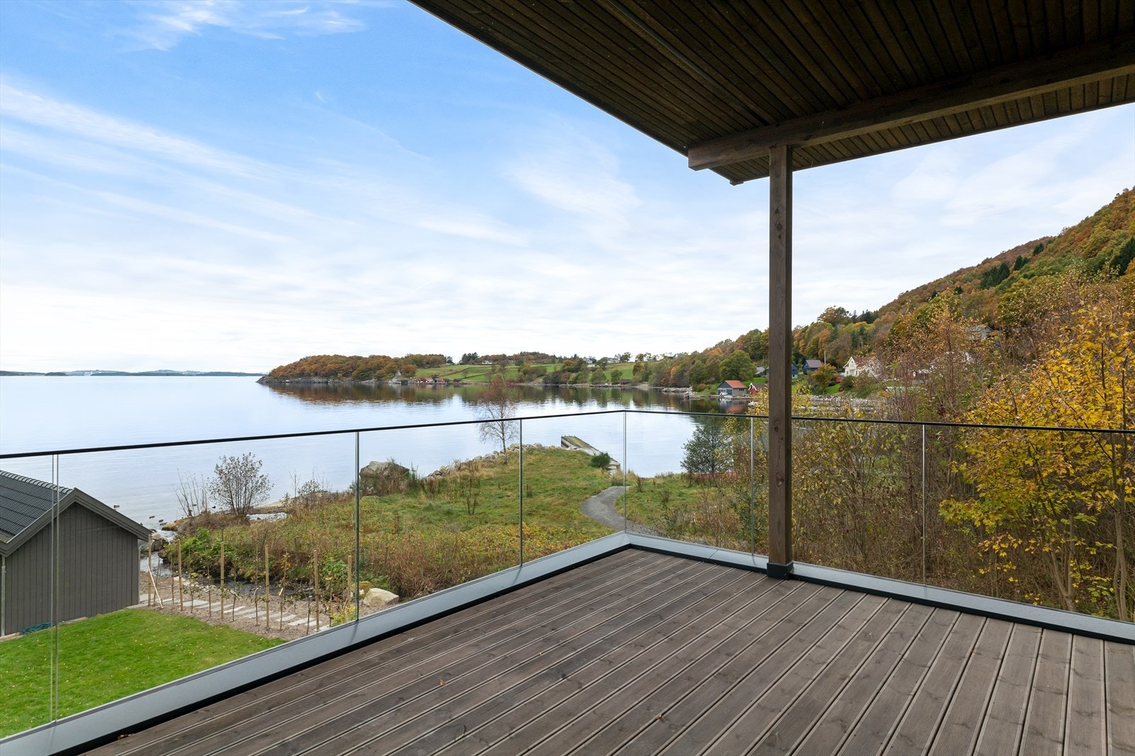 Lun og delvis overbygd terrasse med glassrekkverk og Royal impregnerte terrassebord Galleribilde