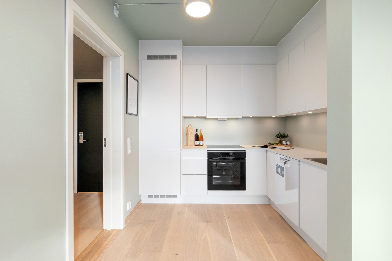 Kjøkkenet er praktisk plassert i en egen krok, som gir et naturlig skille mellom matlaging og avslapping. Galleribilde