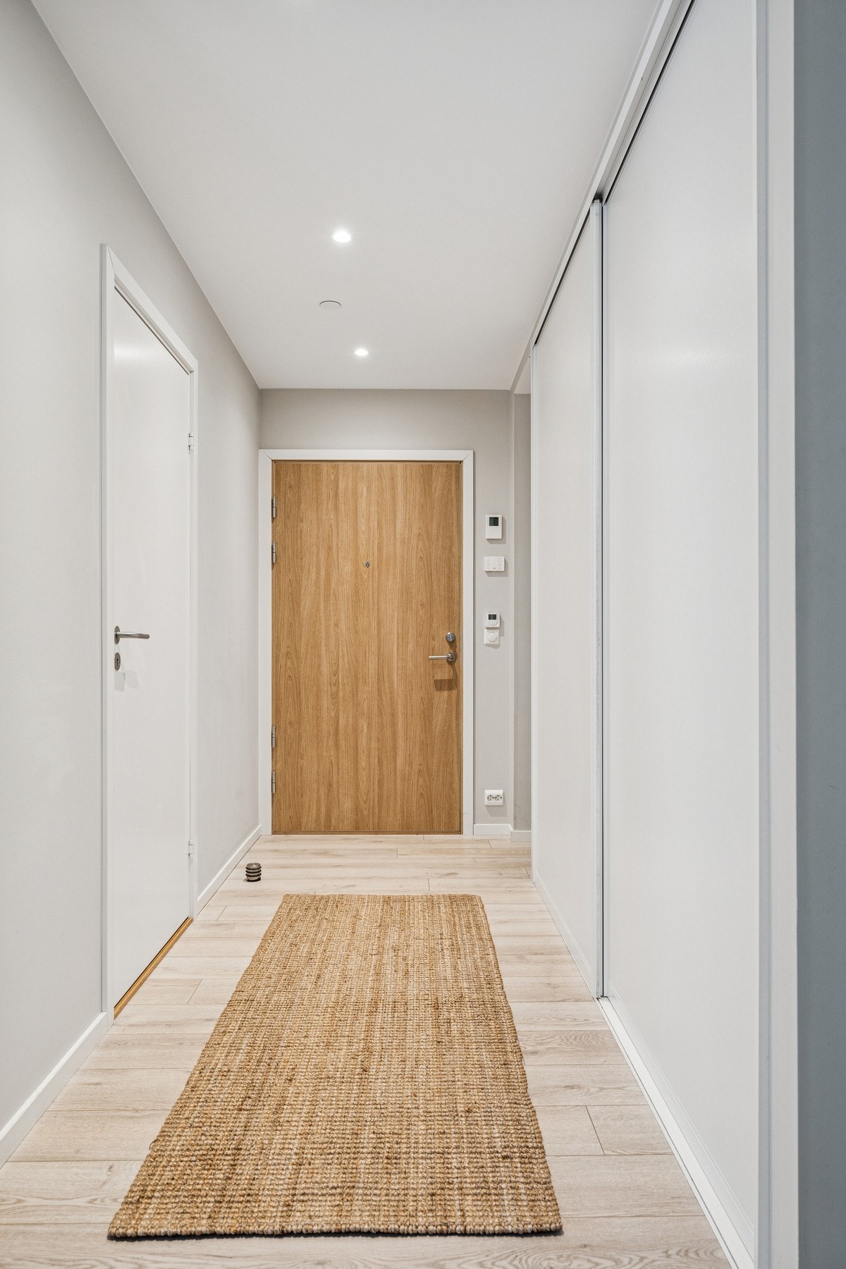 En lys entré med fin plass til oppbevaring av sko og yttertøy i praktisk skyvedørsgarderobe. Galleribilde