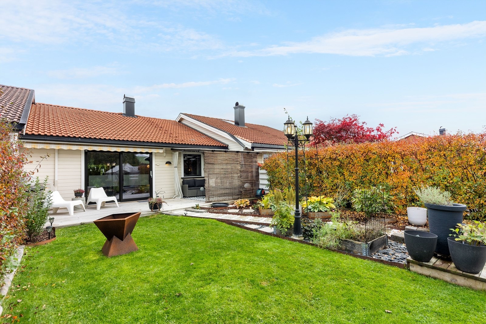 Nydelige hage - en grønn oase med gjennomført opparbeidelse. Her er det både prydplanter, frodig plen og en sjarmerende gangsti som leder til drivhuset - perfekt for deg som liker å dyrke egne grønnsaker, urter eller blomster. Galleribilde