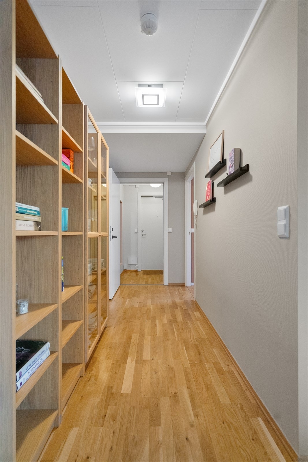 Fra gangen åpner leiligheten seg mot de øvrige rommene. De lyse flatene og parkettgulvet gir et helhetlig og Galleribilde