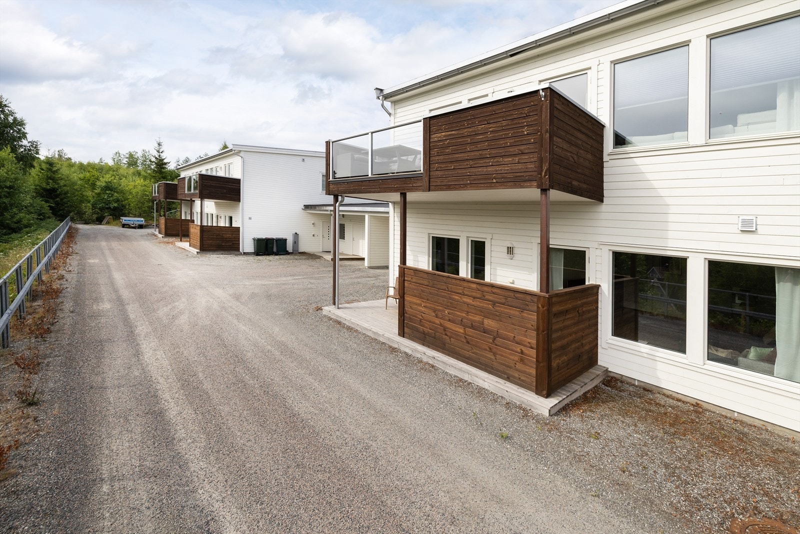 Det er gruset gårdsplass foran lavblokkene. Galleribilde