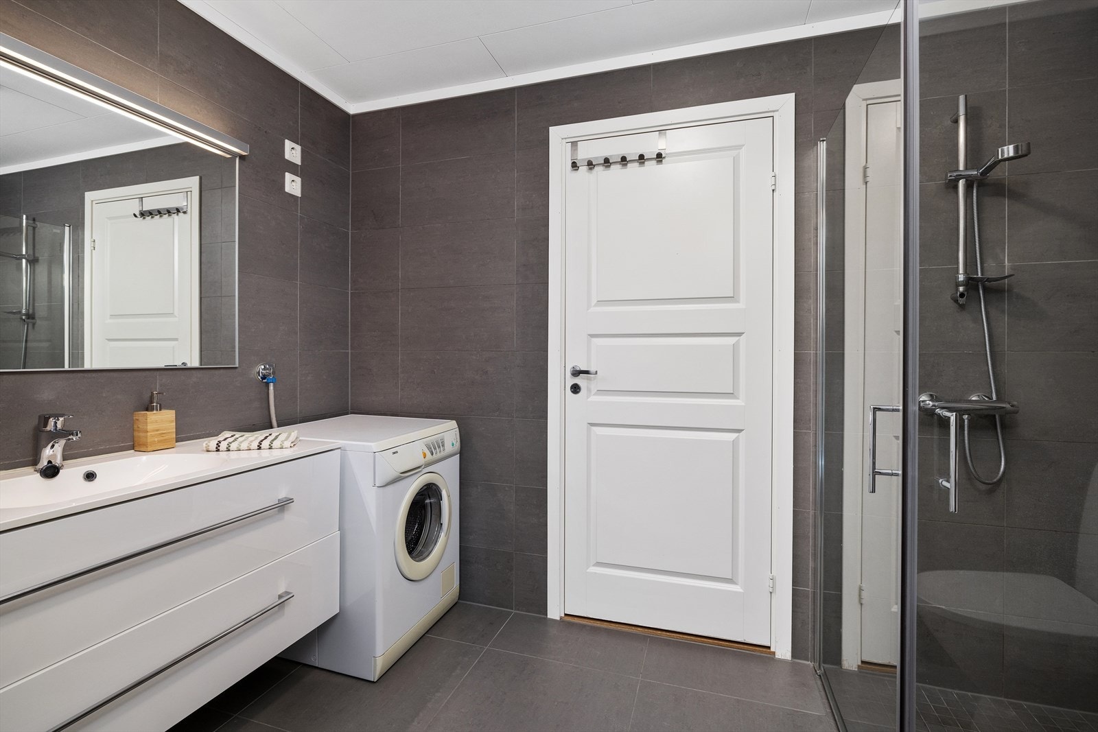 Det er store pene grå fliser på gulv og vegger. Galleribilde