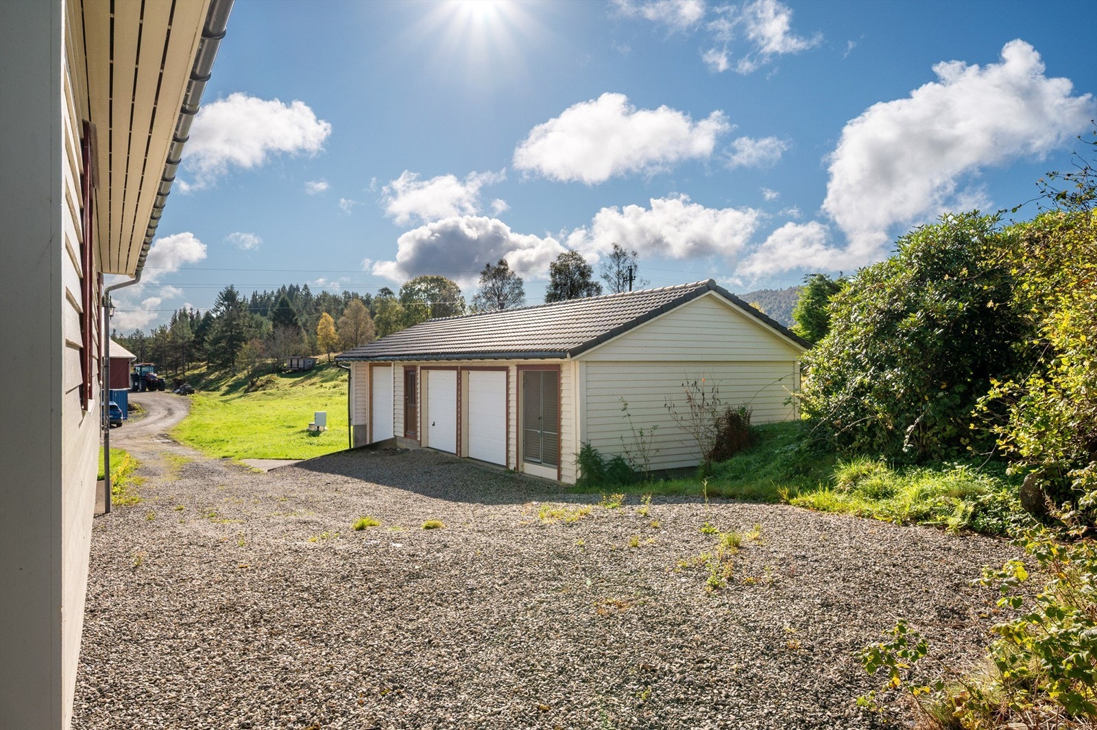 Pent opparbeidet tomt med gruslagt tun, plenareal, diverse beplantinger og garasjebygg. Galleribilde