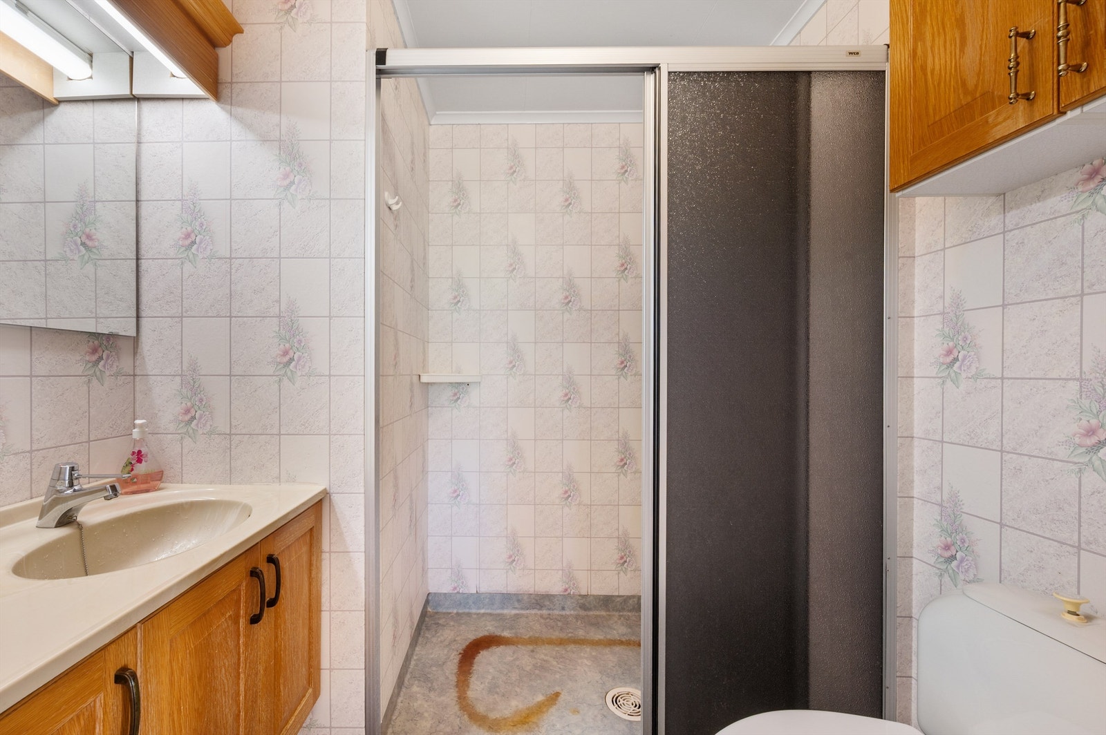 Bad i 2. etasje er av eldre dato og har vegghengt servantinnredning, speil med overlys, gulvstående toalett og dusjnisje. Galleribilde