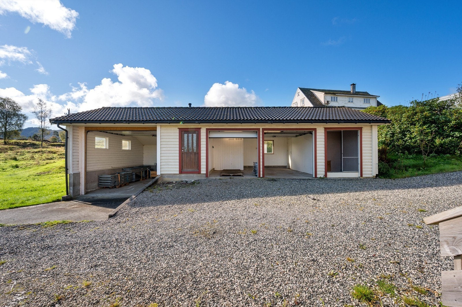 På tomten er det oppført en trippel garasje med boder. Galleribilde