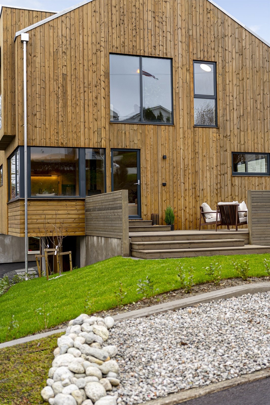 Meget flott opparbeidet tomt med gressplen, steinbed, grus, heller og asfaltert gårdsrom Galleribilde