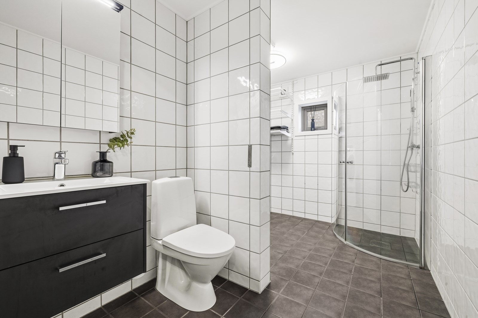 Bad 2 er kombinert bad og vaskerom, og har pene fliser på vegger og gulv, med varmekabler. Galleribilde