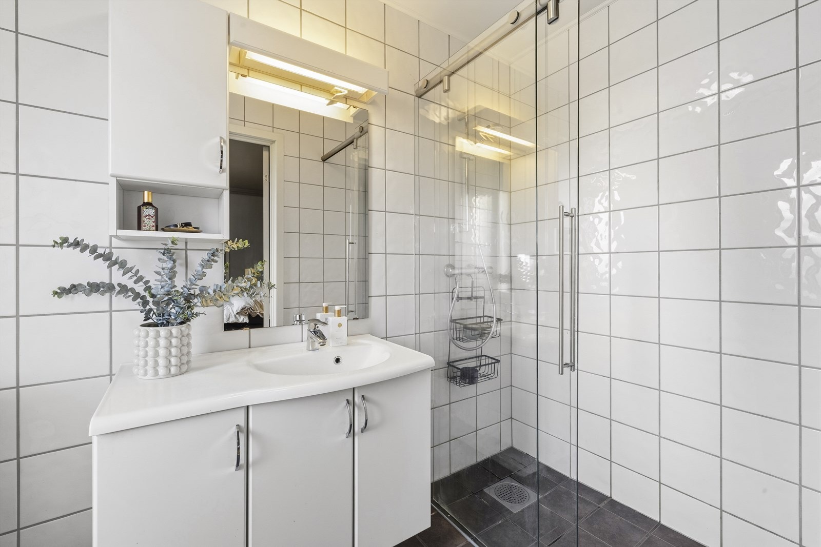 Baderommet består av baderomsinnredning med hel servantplate og skap, dusjhjørne med glassvegger og wc. Galleribilde