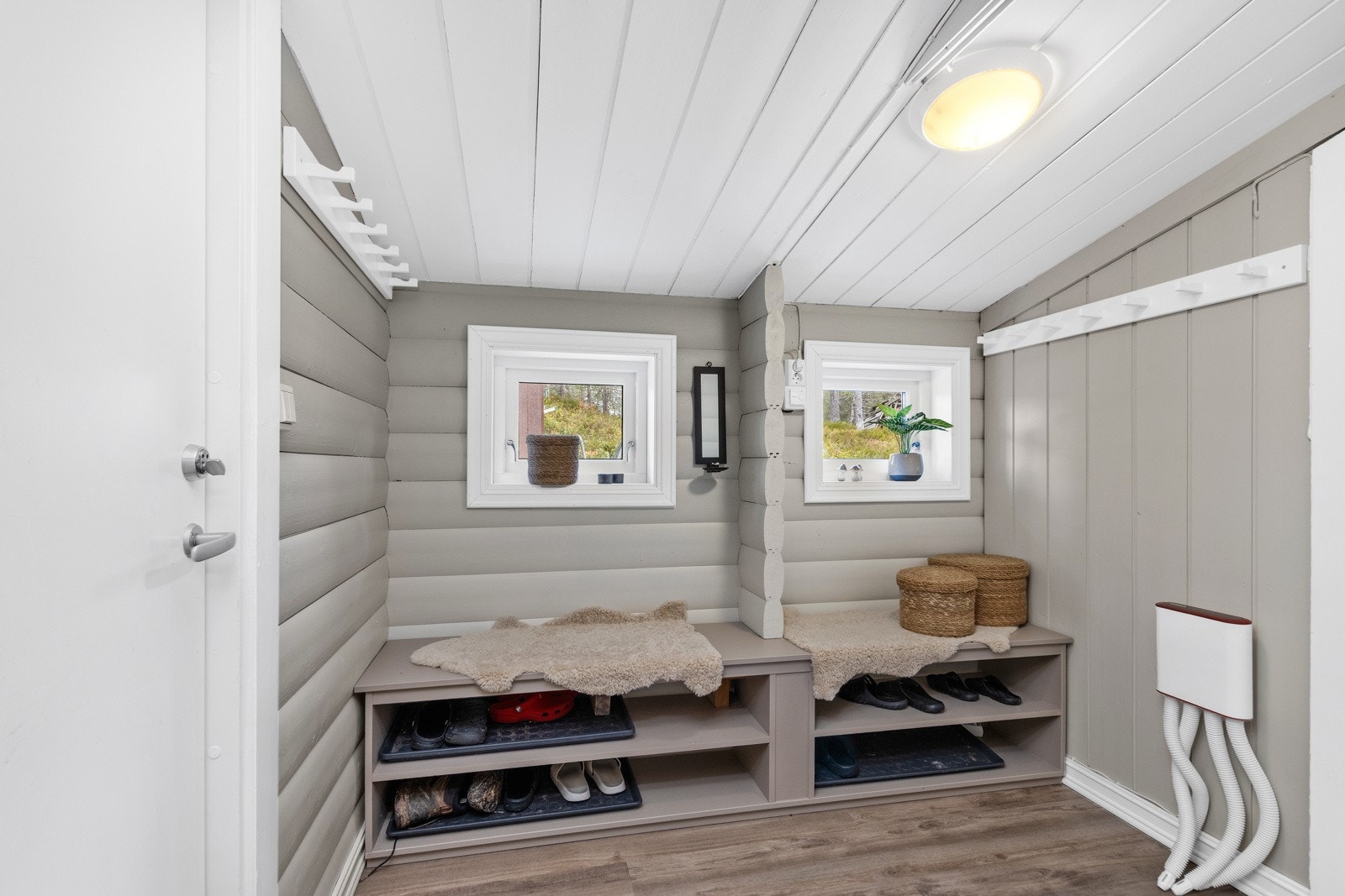 Praktisk entrè med plass for oppbevaring av yttertøy og sko, samt adkomst til toalettrom Galleribilde