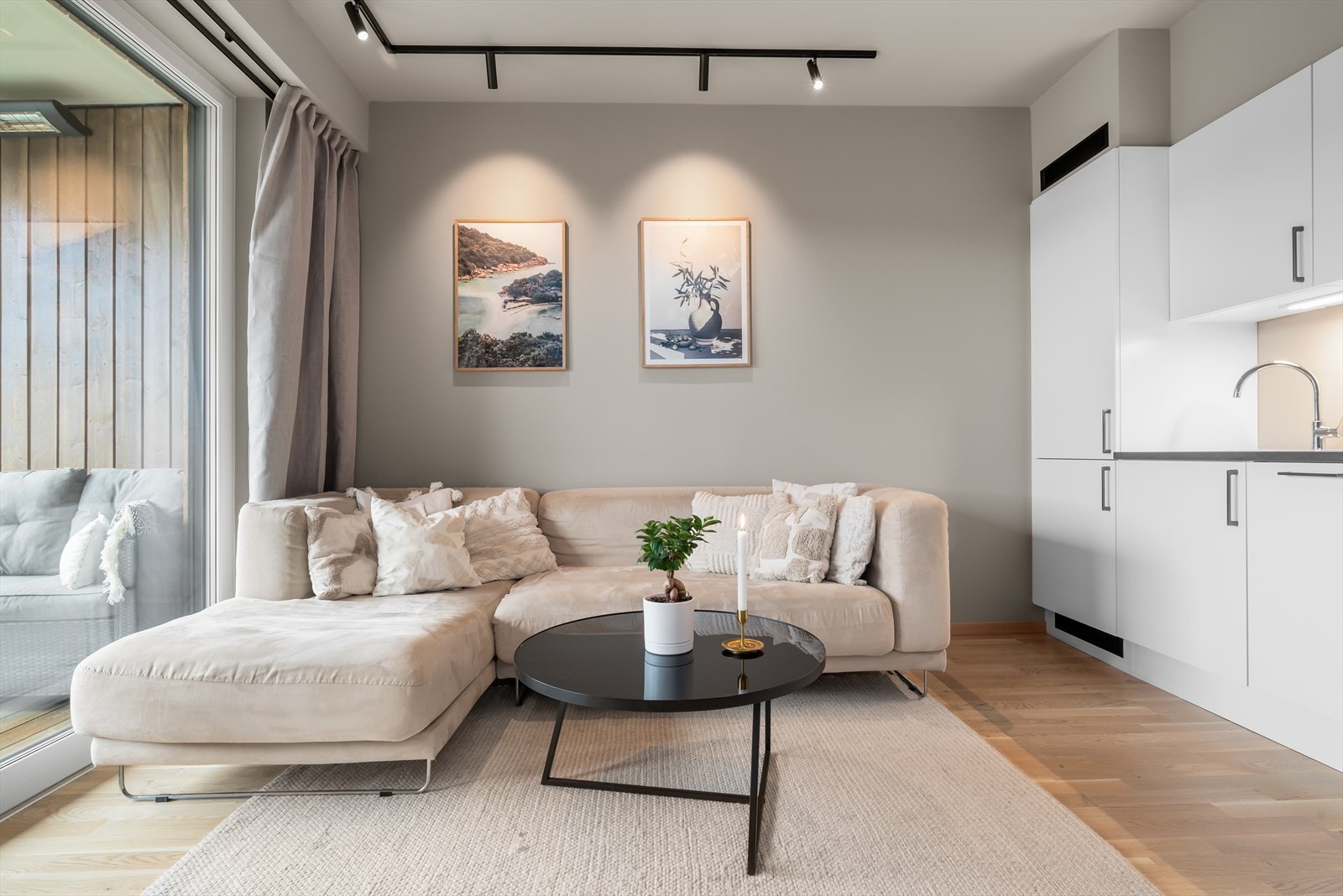 Store vindusflater slipper inn rikelig med dagslys og forsterker den luftige romfølelsen. Sorte detaljer setter et elegant preg på leiligheten. Galleribilde