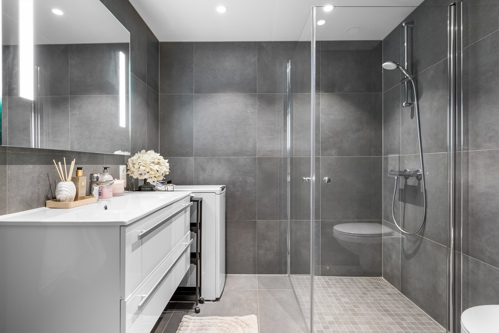 Leiligheten har et moderne og tiltalende baderom på 4 kvm, flislagt og med behagelige varmekabler i gulvet. Galleribilde