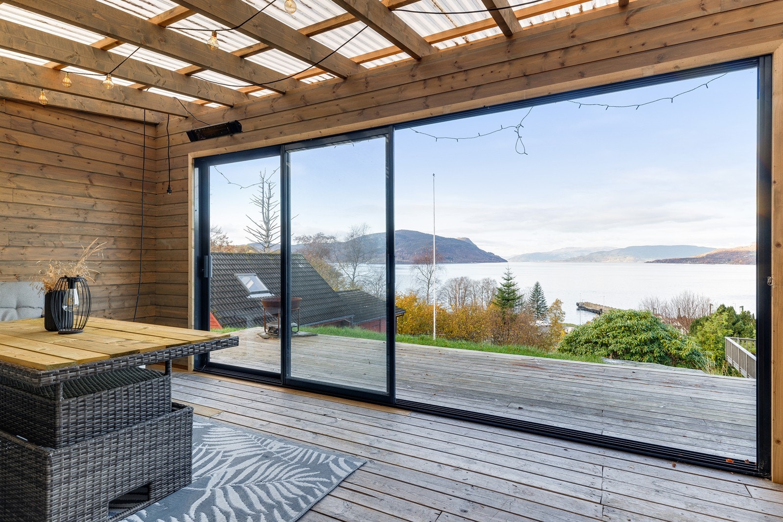 Store vindusflater gir panoramautsikt mot fjorden fra hagestuen. Galleribilde