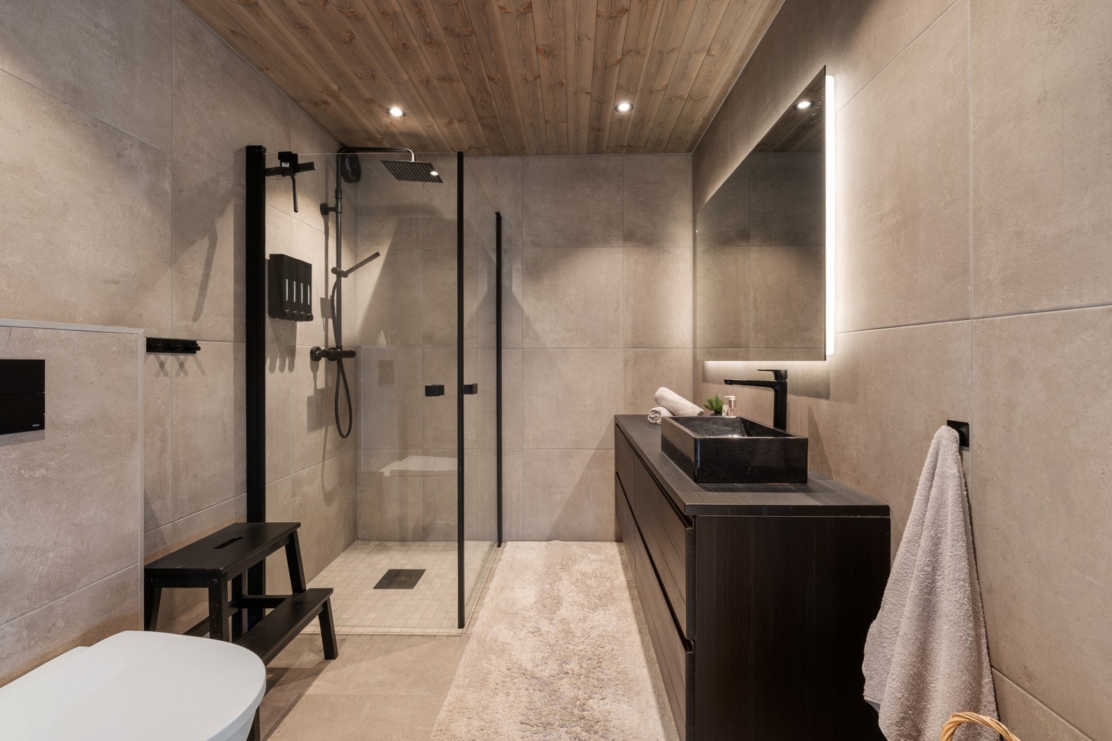 2 lekre bad med dusjhjørne, vegghengt toalett og servant med underskuffer. Galleribilde