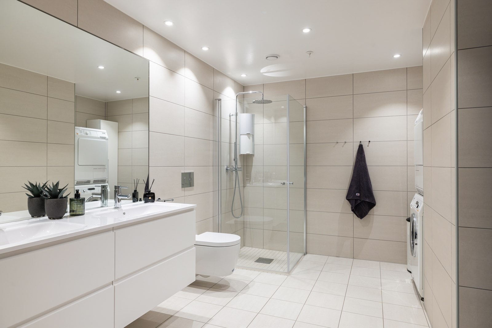 Innredningen består av underskap, servant, speil, vegghengt toalett og dusjhjørne med innfellbare dører. Galleribilde