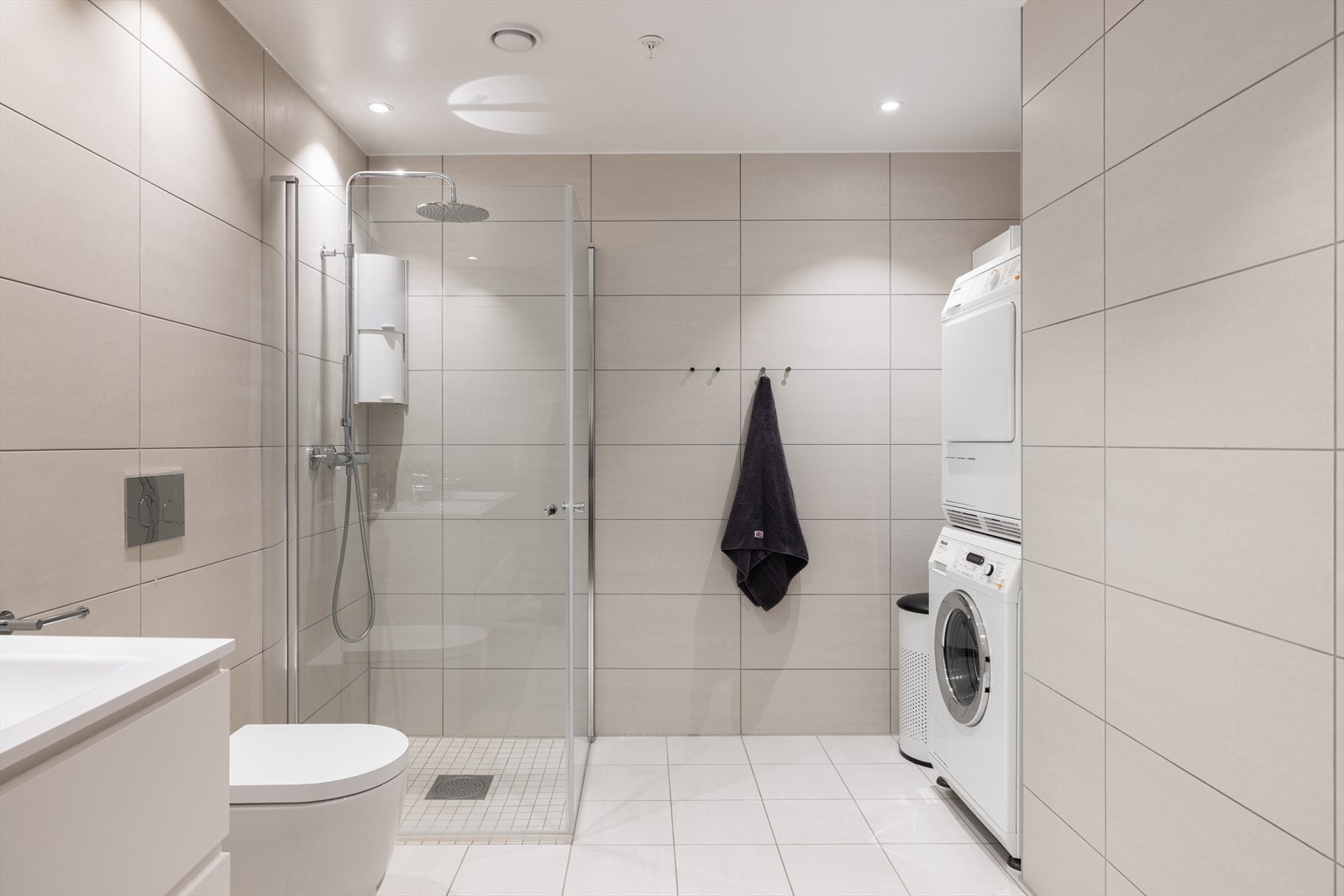 Delikat flislagt bad med elektriske varmekabler og opplegg for vaskemaskin. Galleribilde