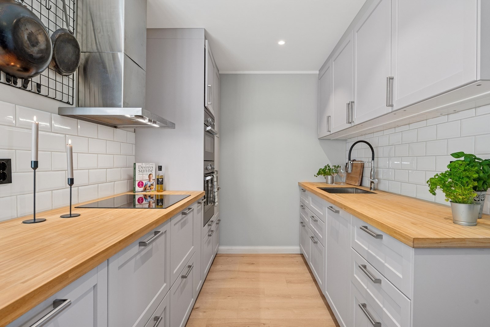 Benkeplaten er av laminat og det er nedfelt en induksjonstopp og en underlimt vaskekum i stål. Galleribilde