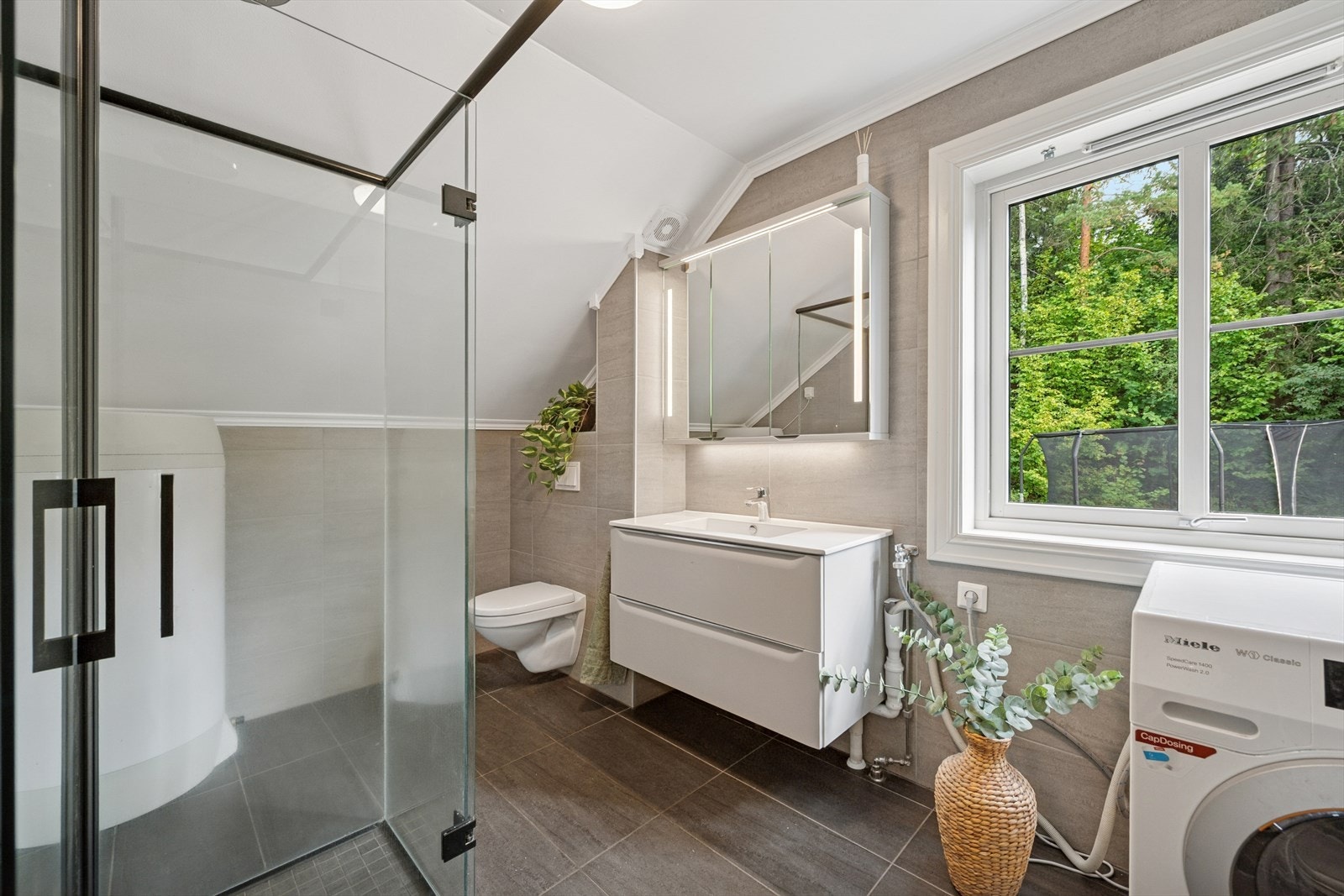 Stilrent bad/vaskerom oppgradert i regi av borettslaget i 2021. Utstyrt med skapinnredning med nedfelt servant, vegghent wc og dusjinnredning. Opplegg for vaskemaskin. Galleribilde