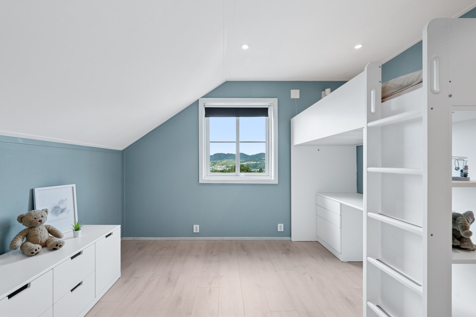 Lyst og romslig soverom med smart løsning med loftseng og skrivepult. Galleribilde