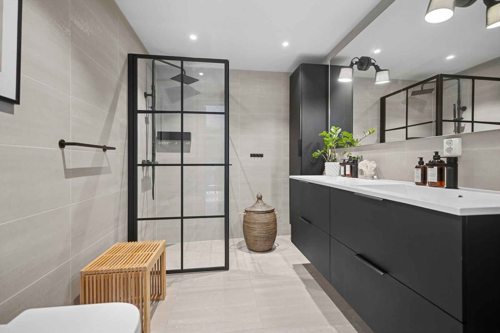 Boligens to baderom ligger i hvert sitt plan, og har samme lyse fliser med gulvvarme og downlights i himling. Galleribilde