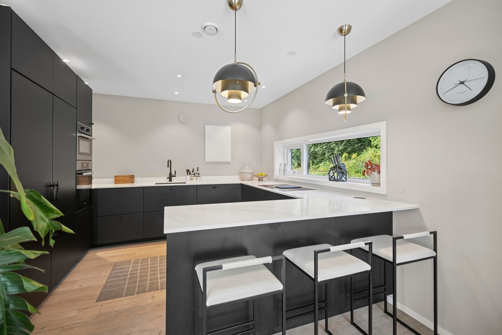 Innholdsrikt kjøkken med hvitevarer fra Miele og benkeplate av kompositt. Galleribilde