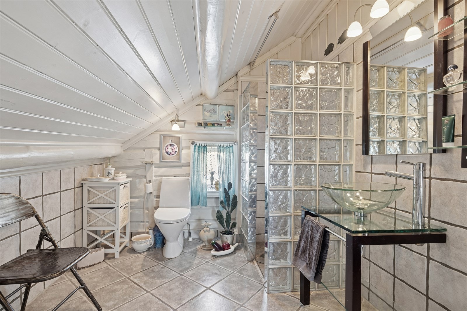 Badet er totalrenovert i 2005, og har fliser på gulv, smøremembran og mansjetter. Dusjhjørne med glassvegger, servant og toalett. Badet har mekanisk avtrekk. Galleribilde