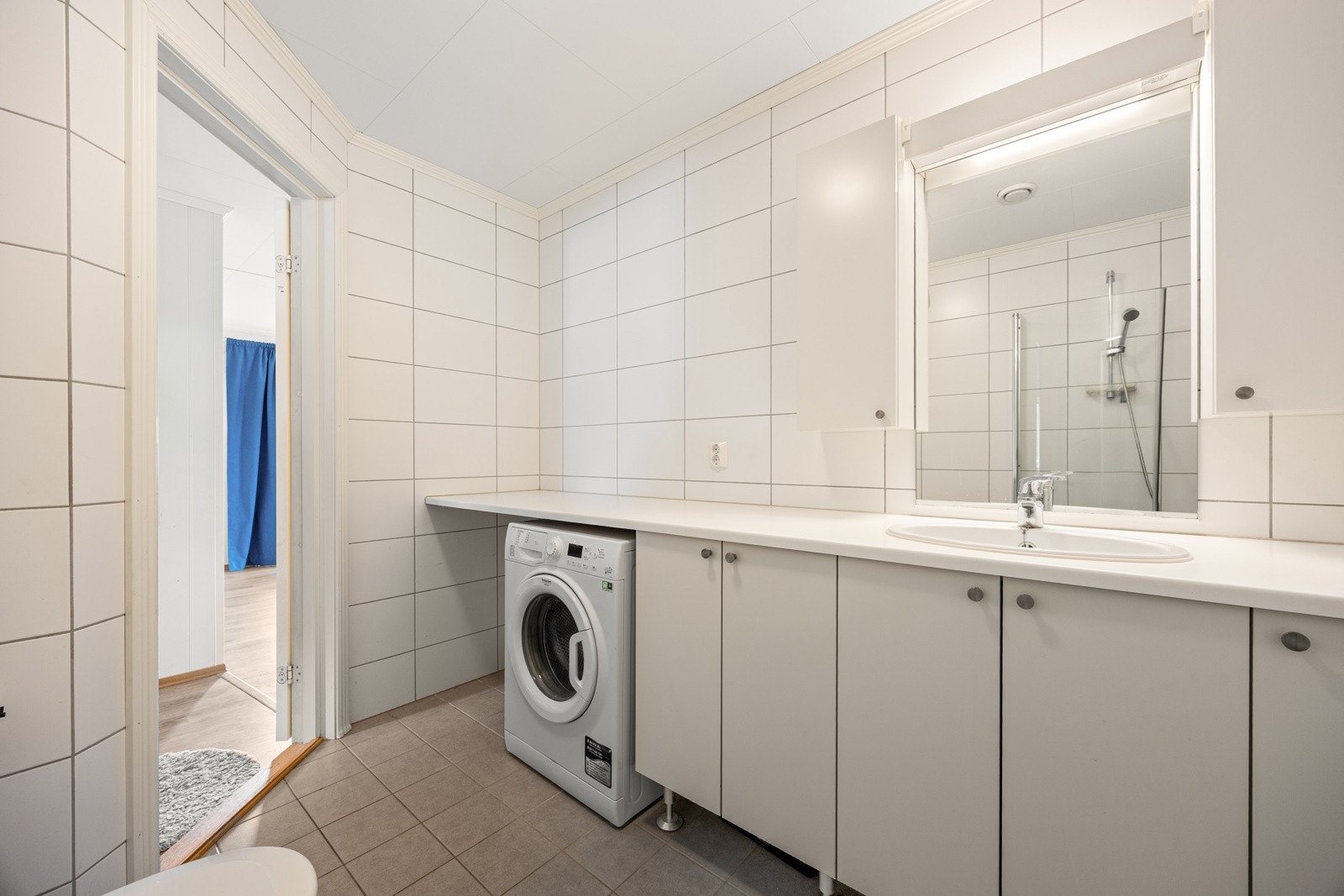 Pent flislagt bad fra byggeår - FDV-dokumentasjon foreligger. Innredningen består av en benkeinnredning med servant, underskap og speil over. Det er plass og opplegg for vaskemaskin under benk, som gir en plassbesparende og praktisk løsning. Galleribilde