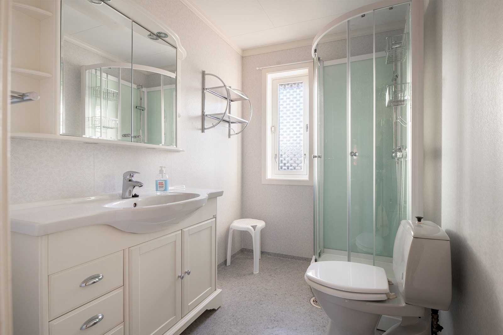 Det lyse, fine badet er pusset opp i 2016, med våtromsbelegg på vegger og gulv. Her er det god oppbevaringsplass i innredning med heldekkende servant, samt i speilskap med overlys og åpne hyller. Badet er også innredet med dusjkabinett og toalett. Galleribilde