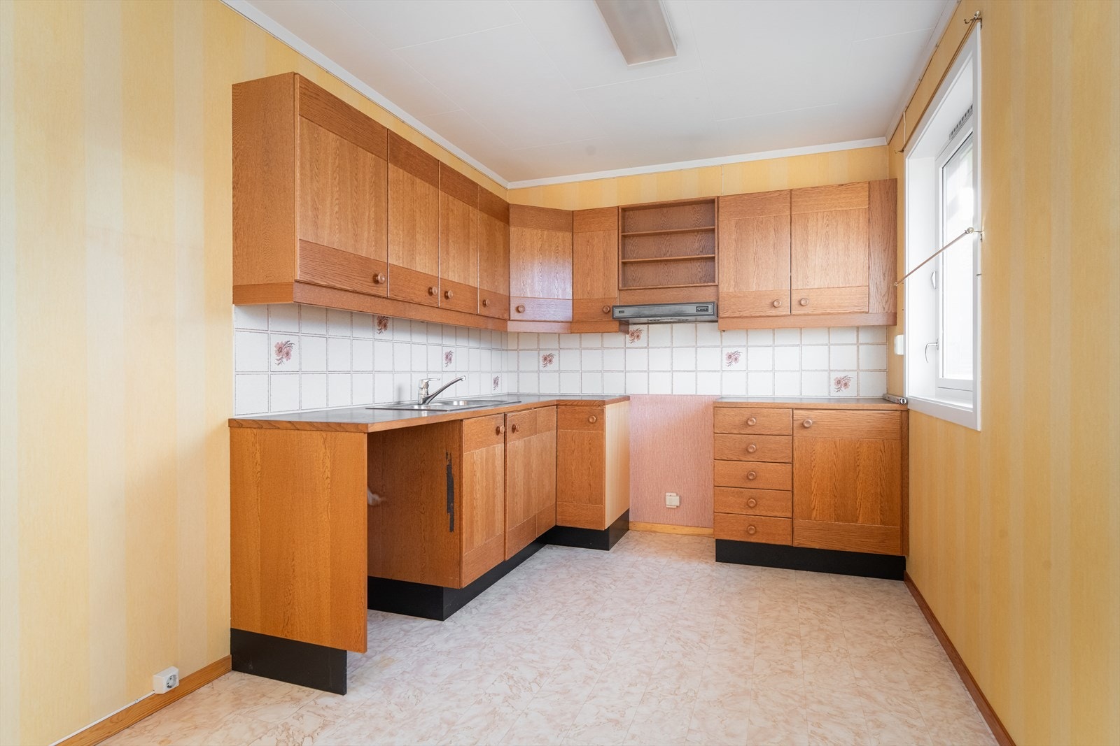 Kjøkkenet har en koselig spiseplass ved det ene vinduet, mens det andre gir godt arbeidslys inn mot innredningen. Kjøkkenet har innredning fra byggeår, med god skap- og benkeplass. Galleribilde