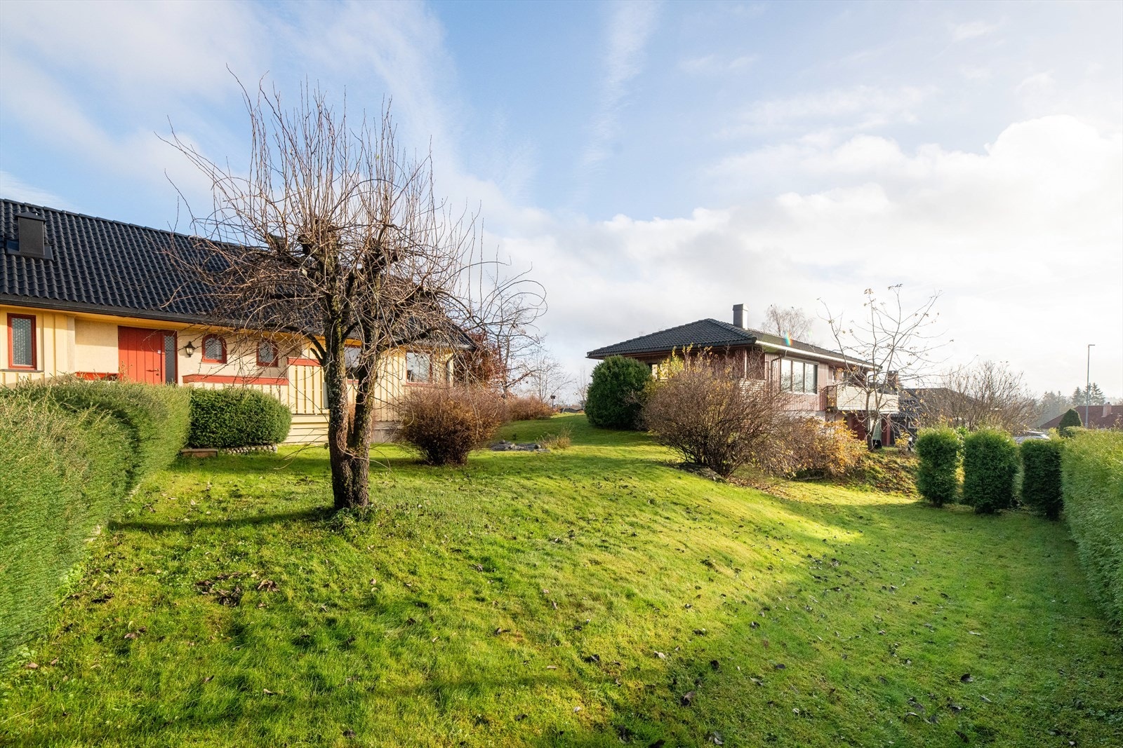 Hagedelen er pent opparbeidet med plenarealer, trær og prydbusker samt noe fjell i dagen. Galleribilde