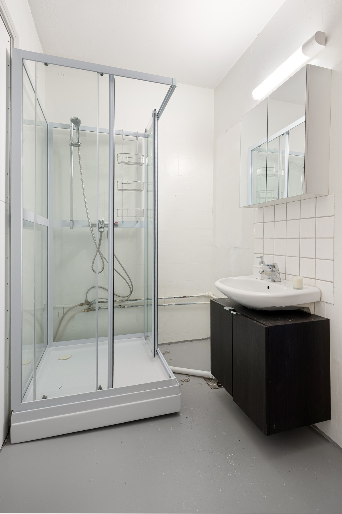 Badet har behov for oppgraderinger og er i dag innredet med dusjkabinett, servant med underskap og speil. Galleribilde